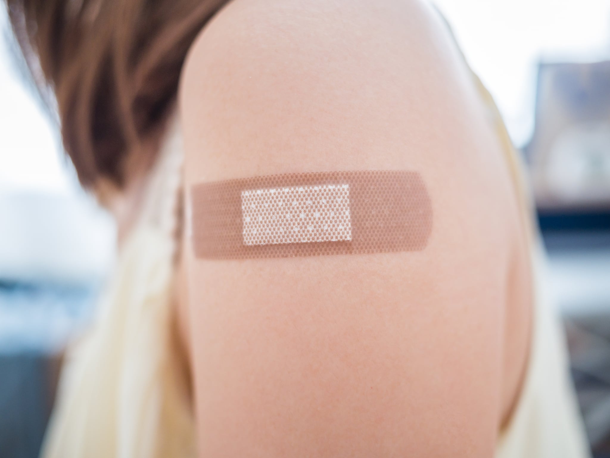 Adhesive bandage on a female arm after vaccination. 