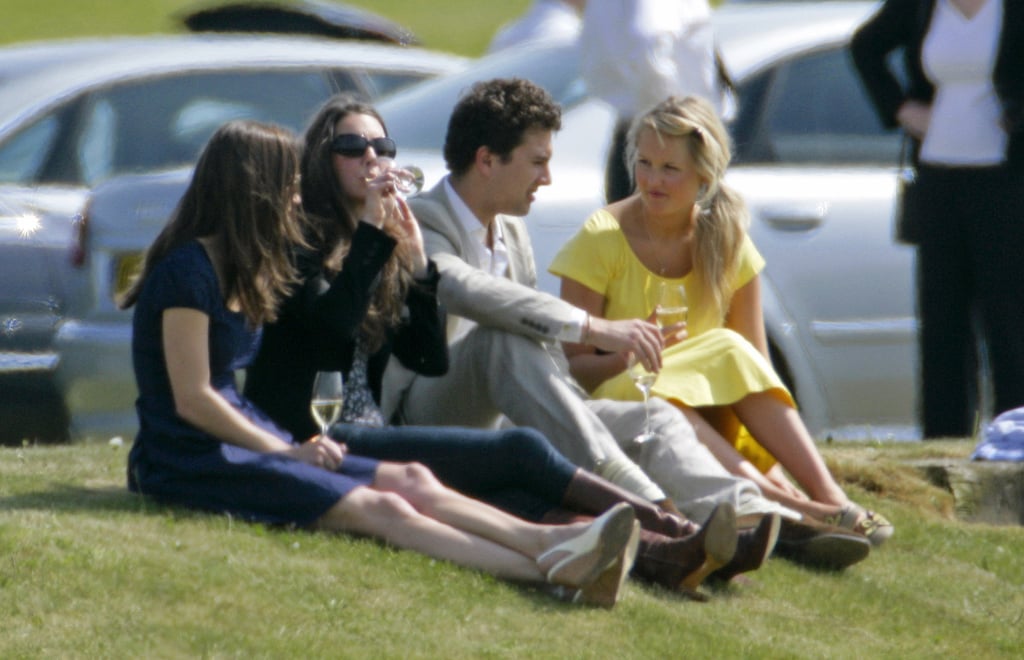 They sit on the grass and drink wine.