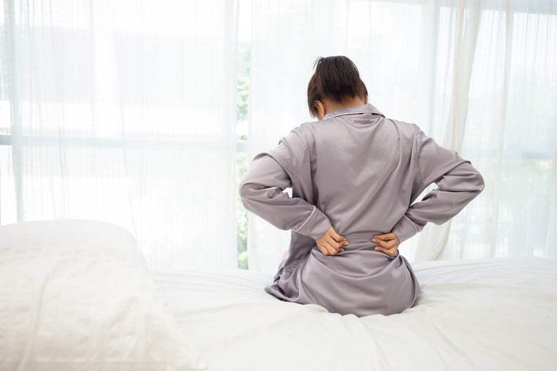 woman have a back pain sitting on bed after wake up in bedroom,Healthcare Concept