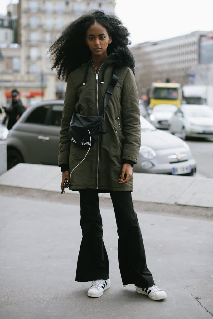 Look effortless off duty in an army-green anorak, flared jeans, and sneakers.
