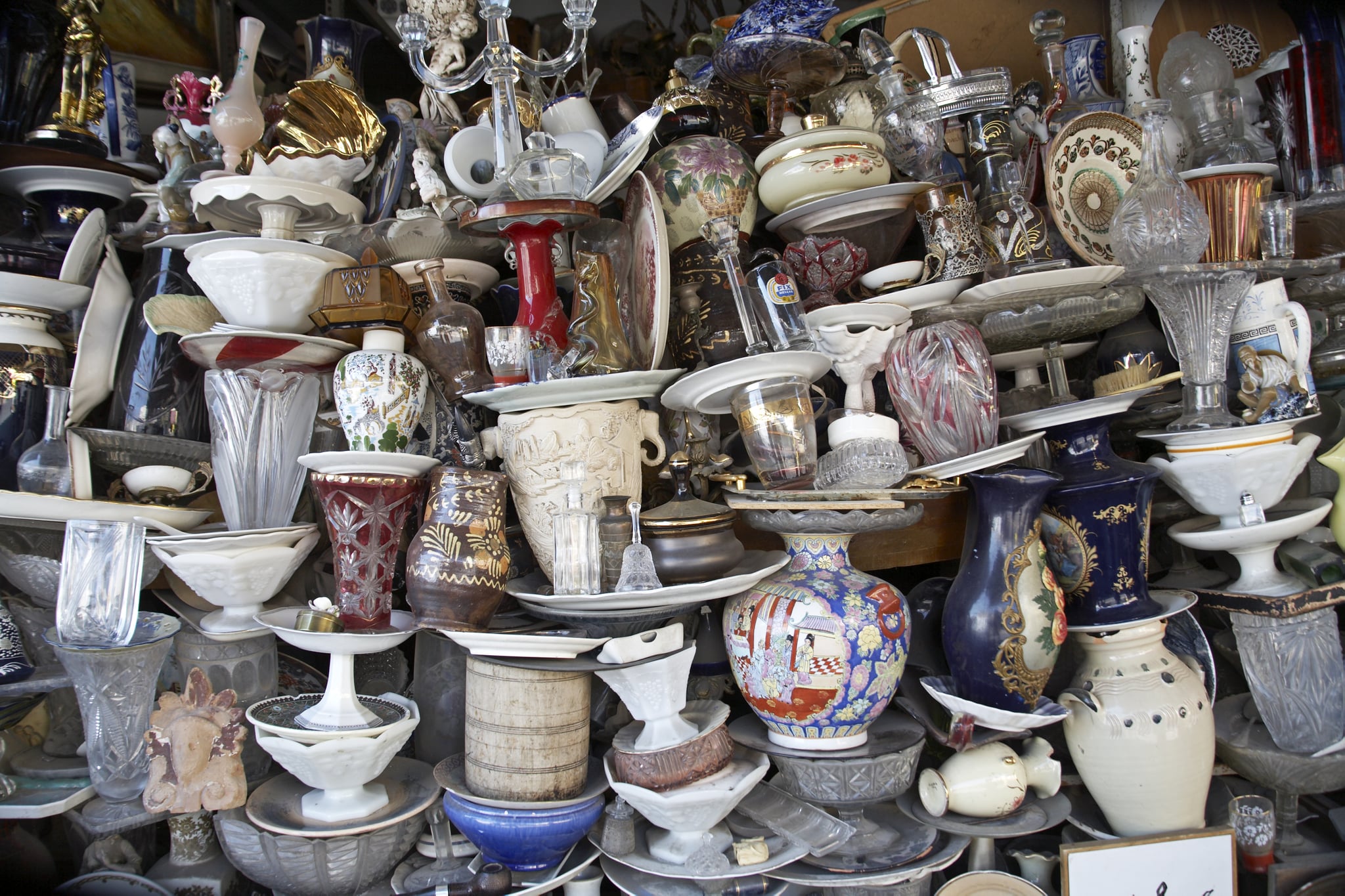 Colourful jumbled, haphazard, mixed, chaotic, glass and china vases and plates on stall in tourist market,  Monastiraki, Plaka,  Athens, Greece