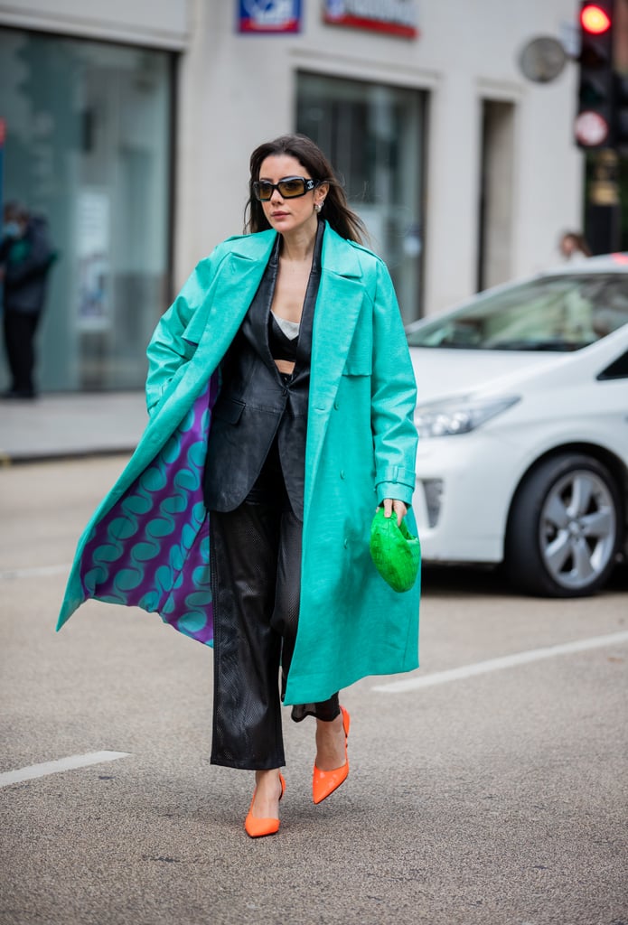 This outfit works because the black leather suit acts as a backdrop for neon green, blue, and orange accessories.