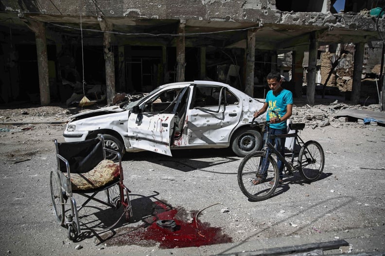 A Syrian boy walks his bike through Douma after an airstrike on the rebel-held territory.