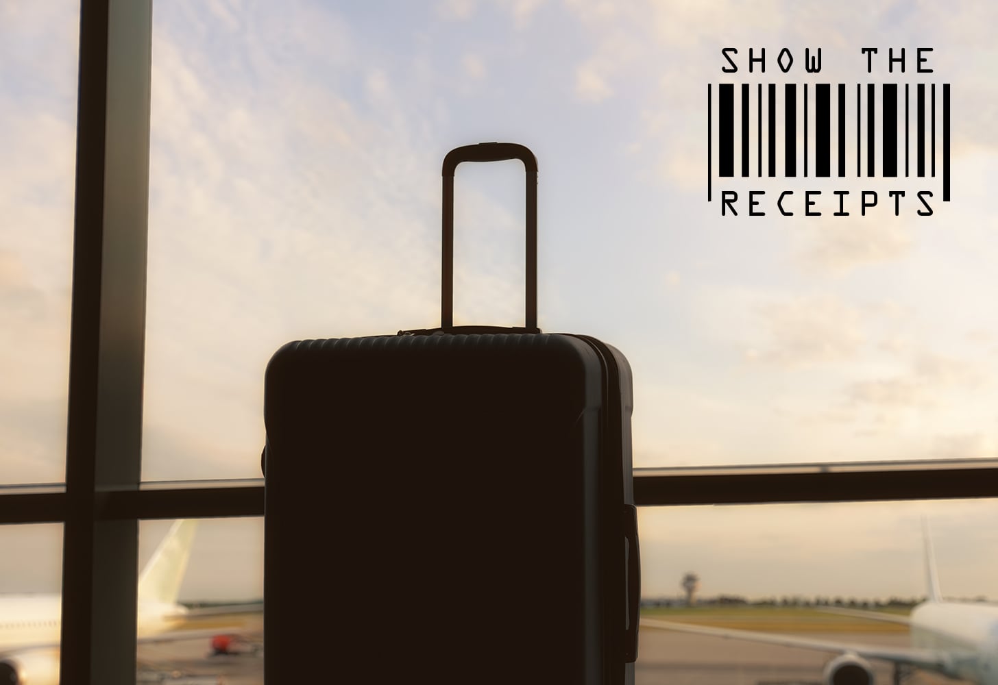 Suitcase sitting by the window of an airport facing planes.