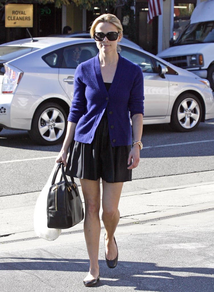 Reese was snapped taking a stroll in a simple black dress, a cardigan, and comfy flats.