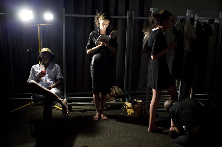 A Model Found A Spot Of Light To Read Her Book Backstage During Models Reading Books