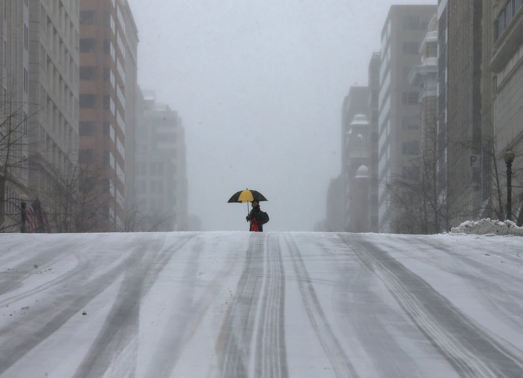 A lone walker made their way across a snow-covered street in DC.