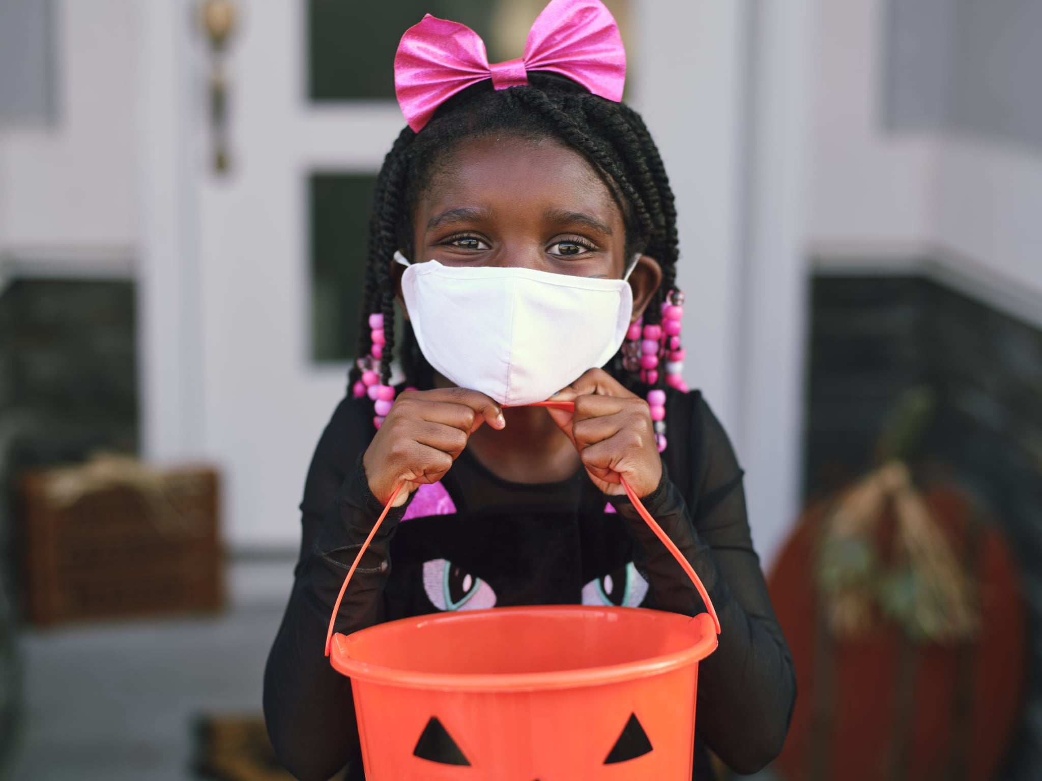 Children trick or treating on Halloween wearing facemarks for protection.