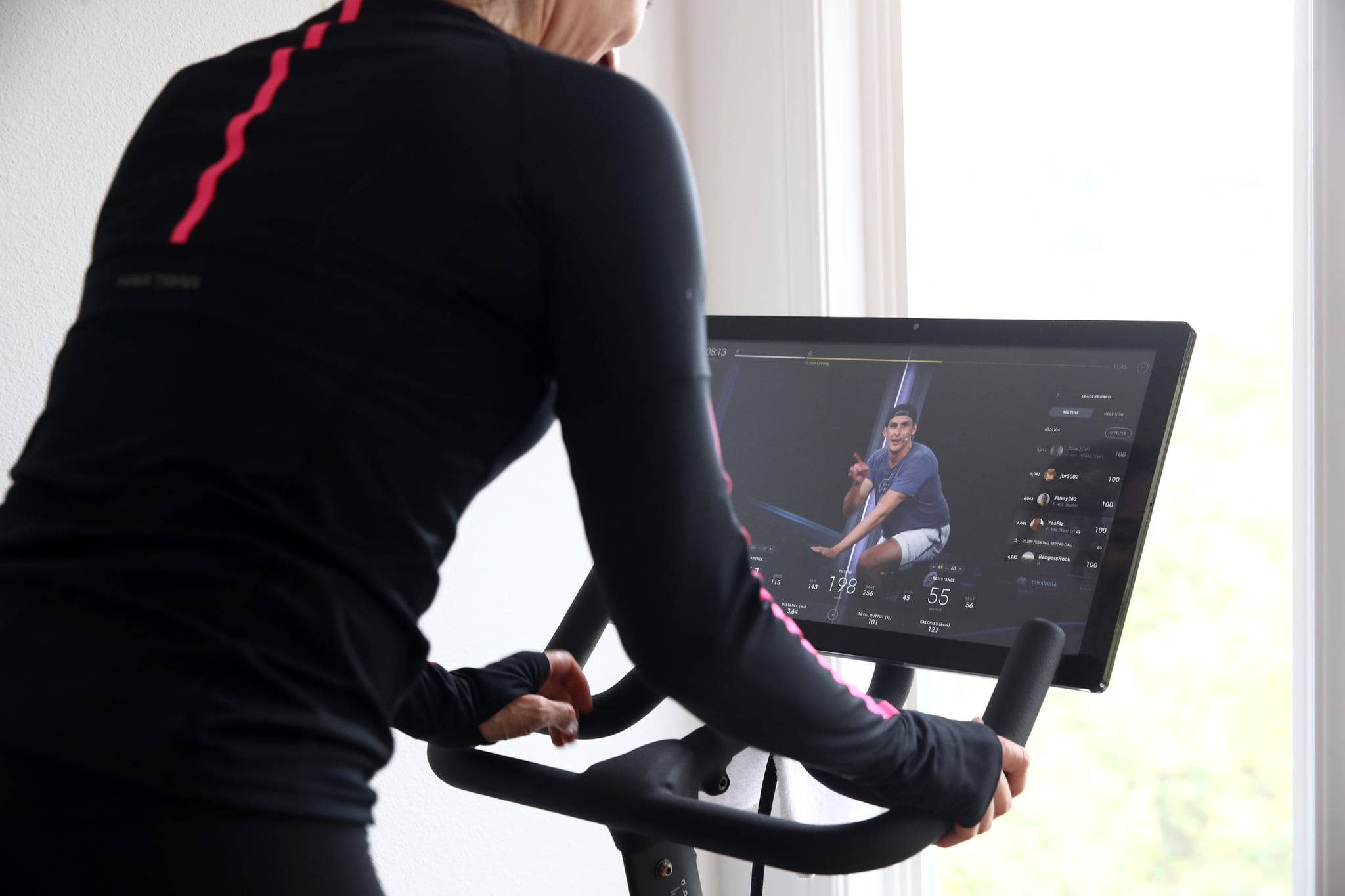 SAN ANSELMO, CALIFORNIA - APRIL 06: Cari Gundee rides her Peloton exercise bike at her home on April 06, 2020 in San Anselmo, California.  More people are turning to Peloton due to shelter-in-place orders because of the coronavirus (COVID-19). Peloton stock has continued to rise over recent weeks even as most of the stock market has plummeted. However, Peloton announced today that they will temporarily pause all live classes until the end of April because an employee tested positive for COVID-19.  (Photo by Ezra Shaw/Getty Images)