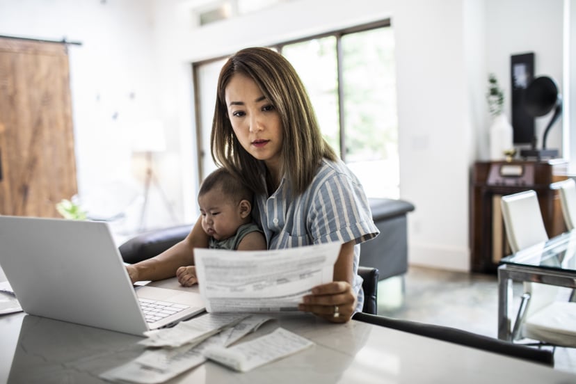 Mother working from home while holding baby