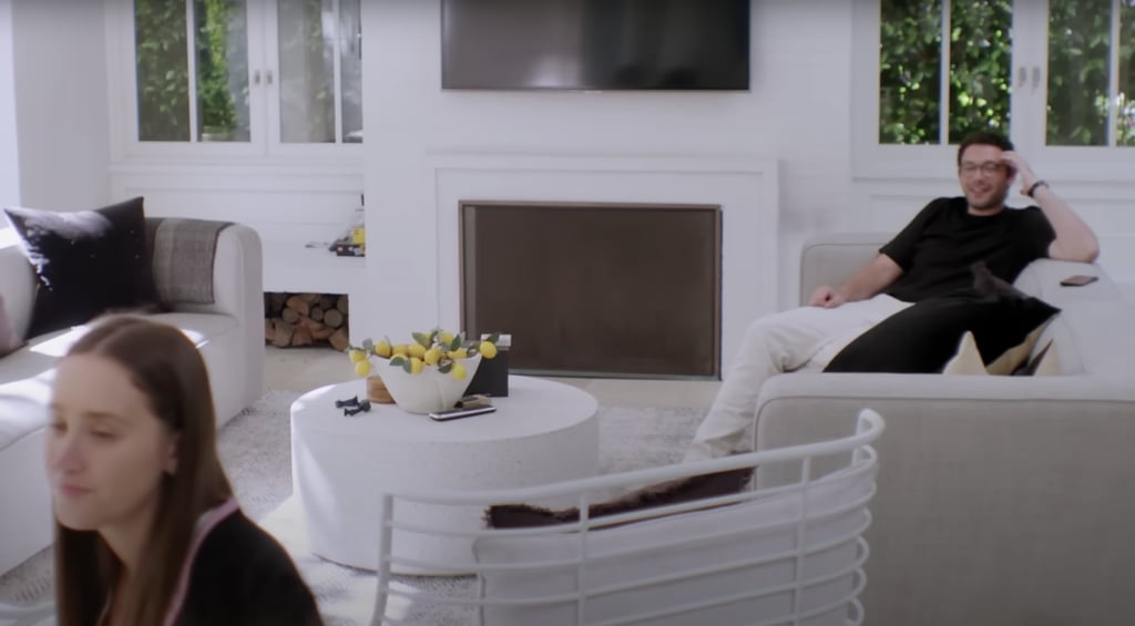 This sitting area has muted couches, a fireplace, and a circular coffee table topped with tiny lemons.