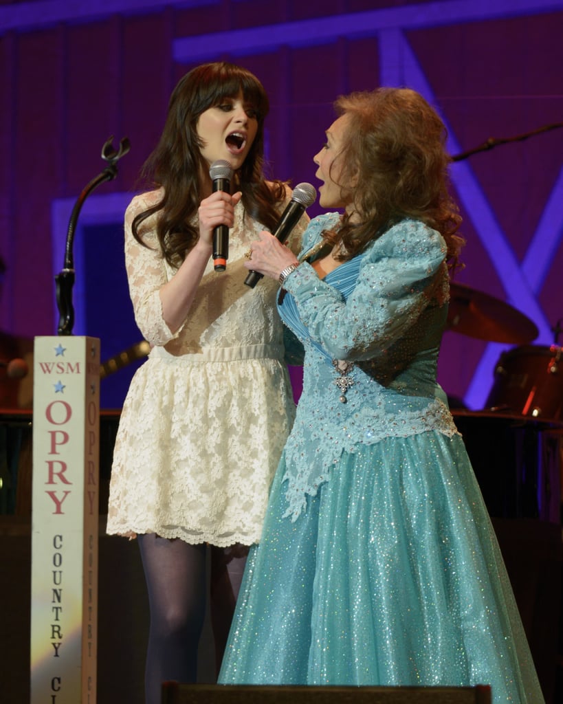 Zooey joined country legend Loretta Lynn on stage in a flared (and flirty) white lace number and dark tights.