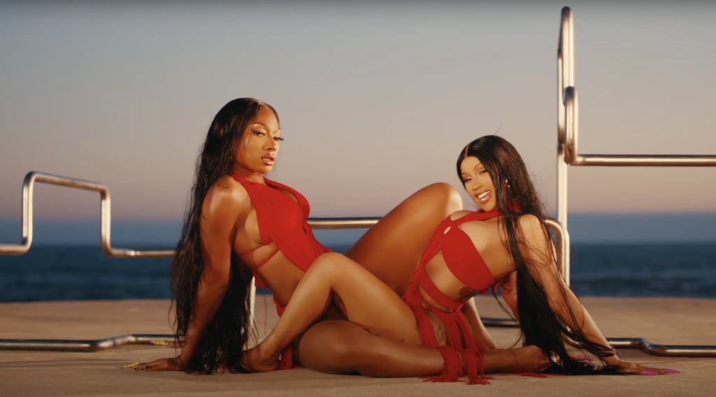Cardi and Megan have their "Baywatch" moment in red one-pieces also made by Matthew Reisman.