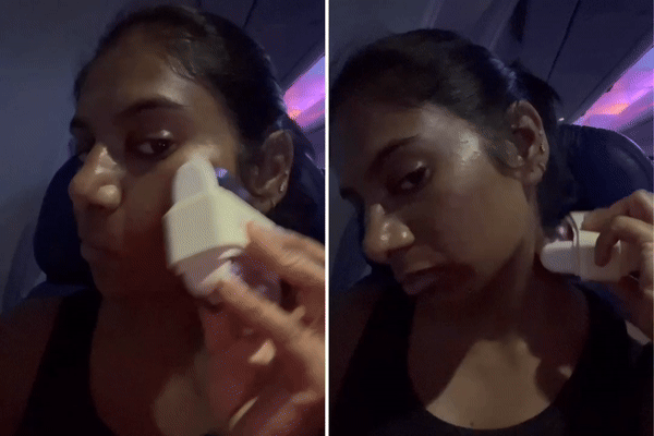 Woman massaging face and neck with the The Skinny Confidential Mint Roller.