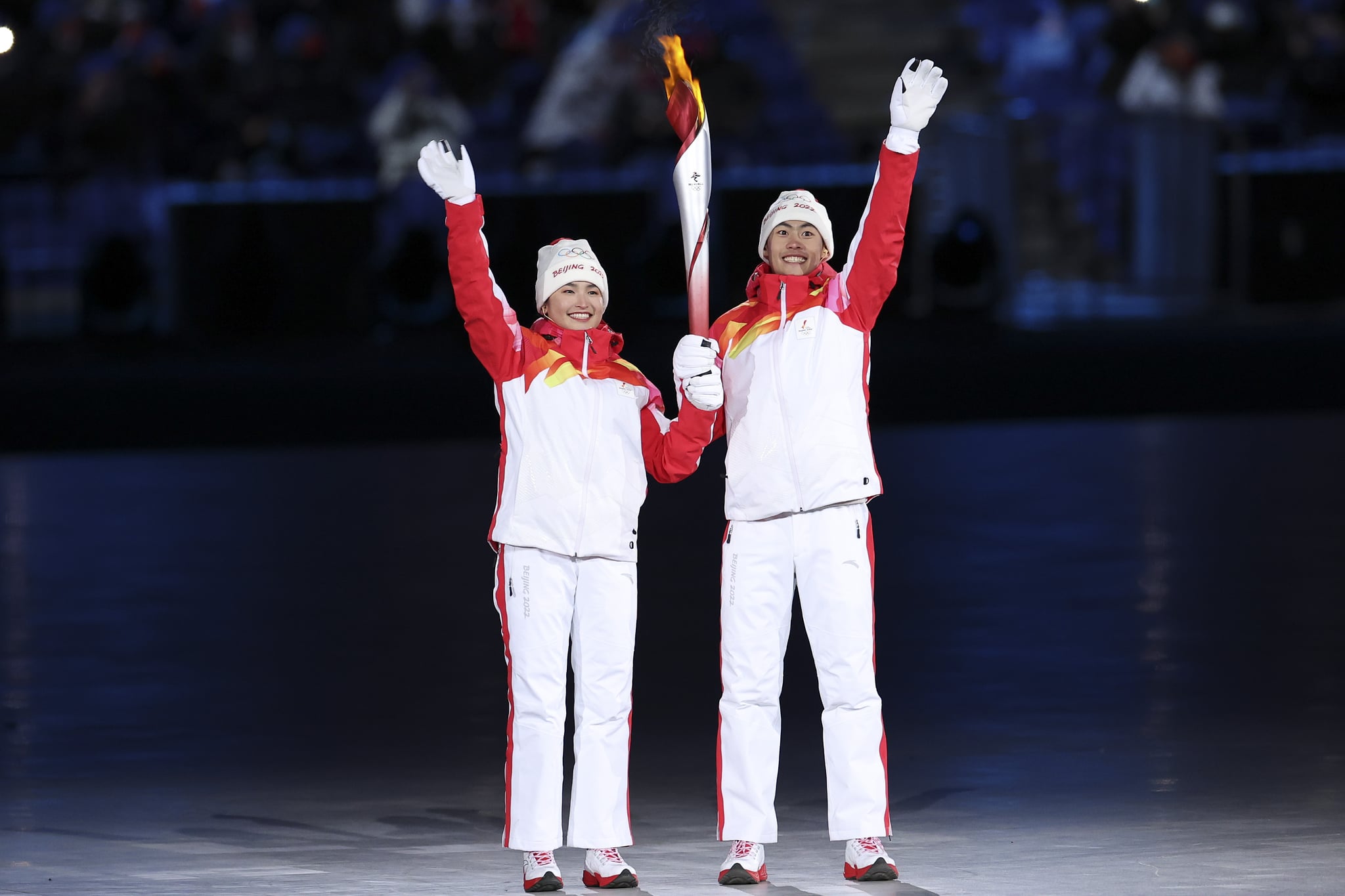 BEIJING, CHINA - FEBRUARY 04: Chinese torchbearer athletes Dinigeer Yilamujian and Zhao Jiawen hold the Olympic flame during the opening ceremony of the Beijing 2022 Winter Olympic Games at the National Stadium on February 04, 2022 in Beijing, China. (Photo by Lintao Zhang/Getty Images)