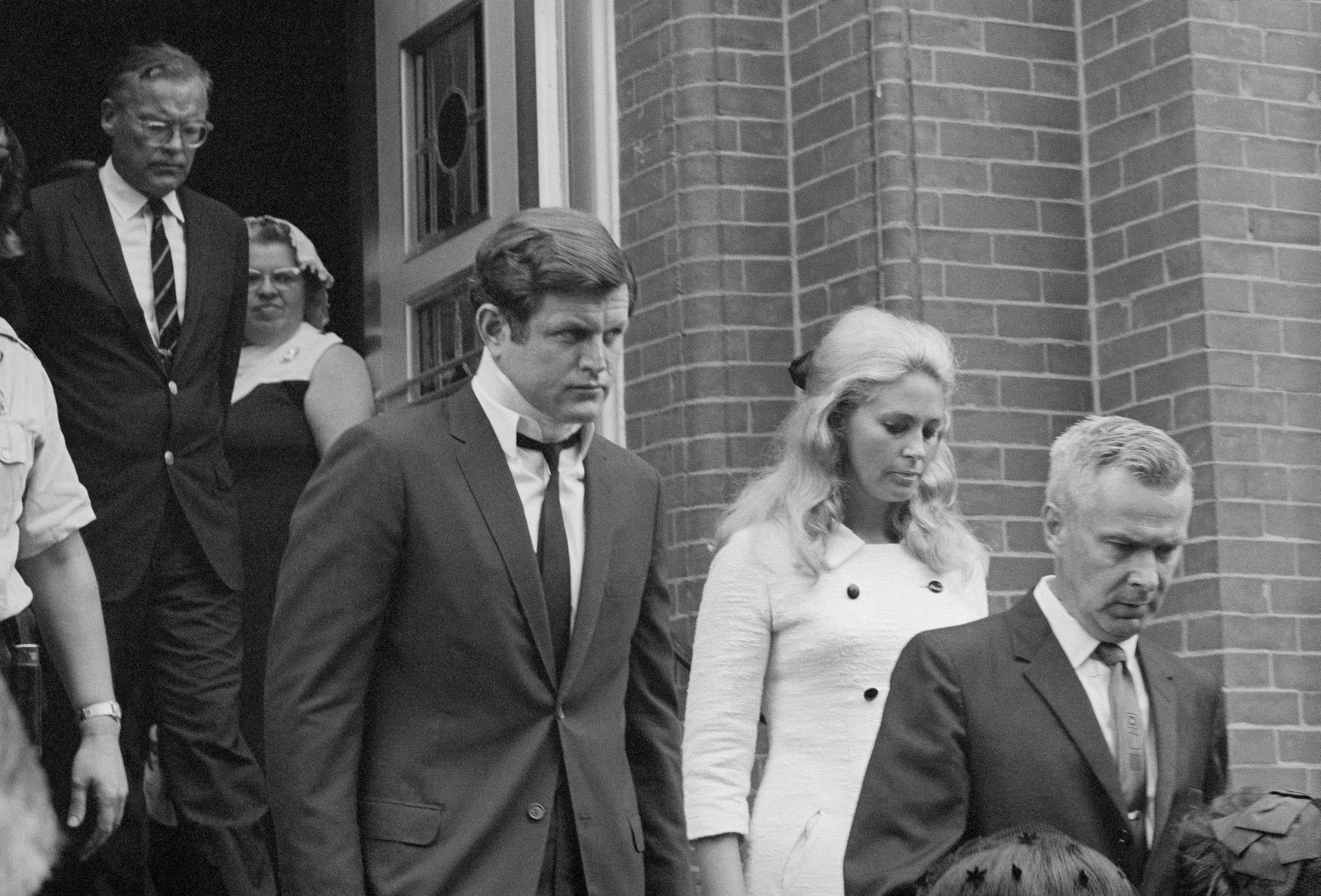 (Original Caption) Plymouth, PA: Sen. Edward Kennedy leaves St. Vincent's Church with his wife, Joan after attending the funeral Mass celebrated for Mary Jo Kopechne, who was killed in an auto crash with the Senator. Mary Kopechne was on the secretarial staff of the late Sen. Robert Kennedy.