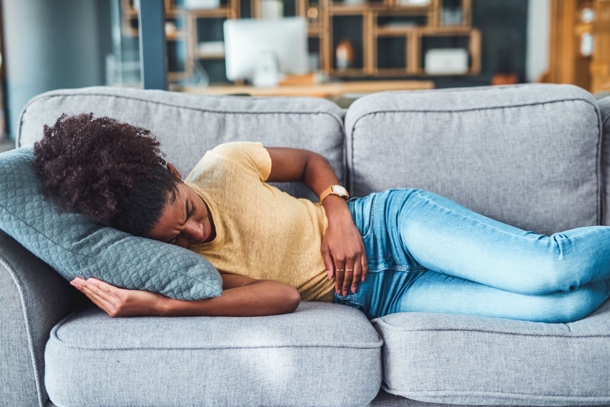 Shot of a young woman experiencing stomach pain during menstrual cycle