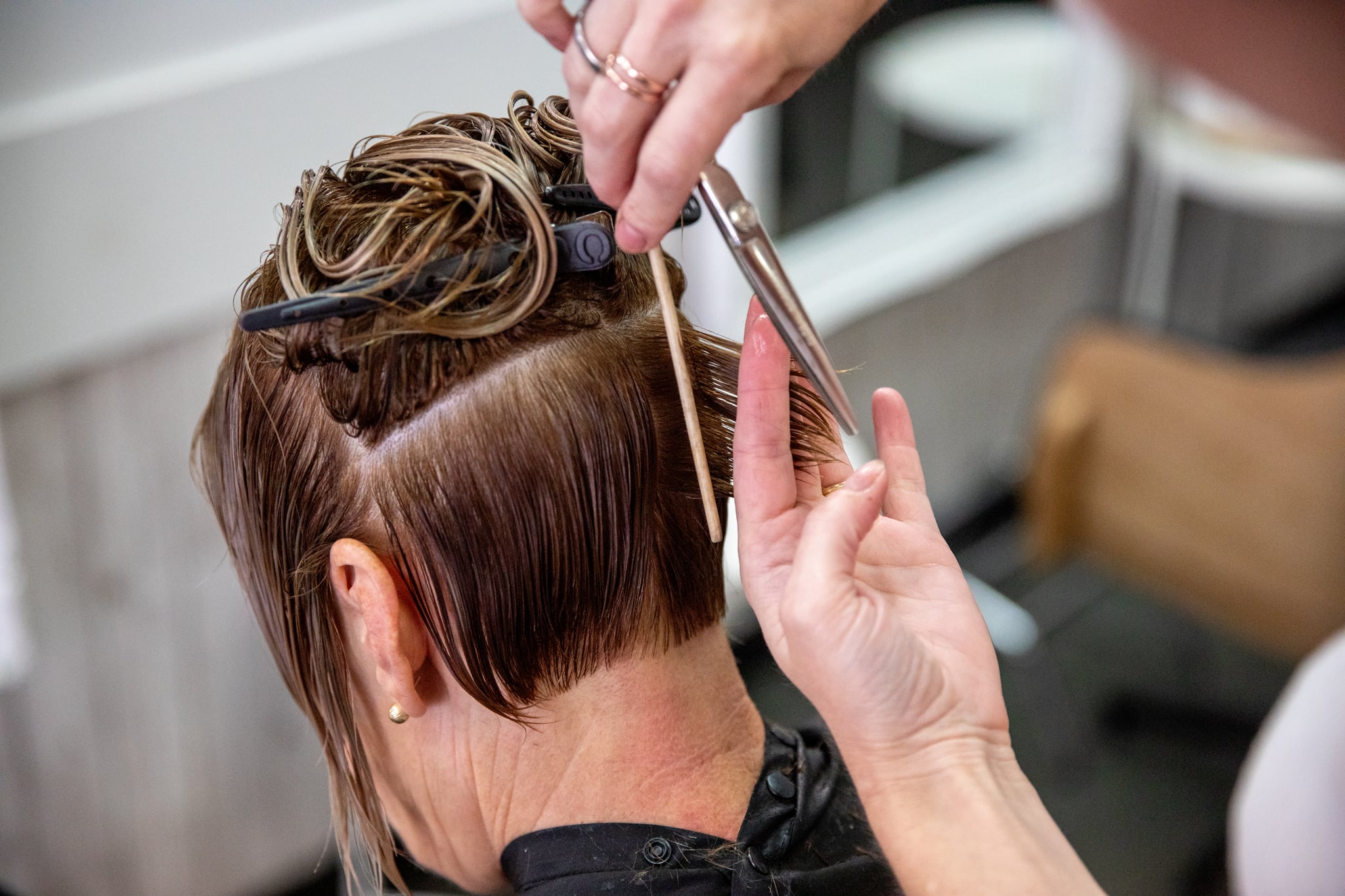 cutting women's short hair with clippers