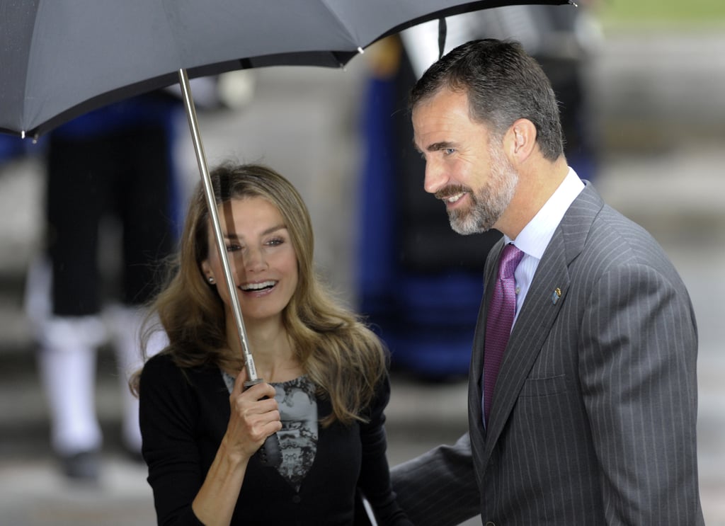 Princess Letizia and Prince Felipe shared a laugh on a rainy day in October 2013.