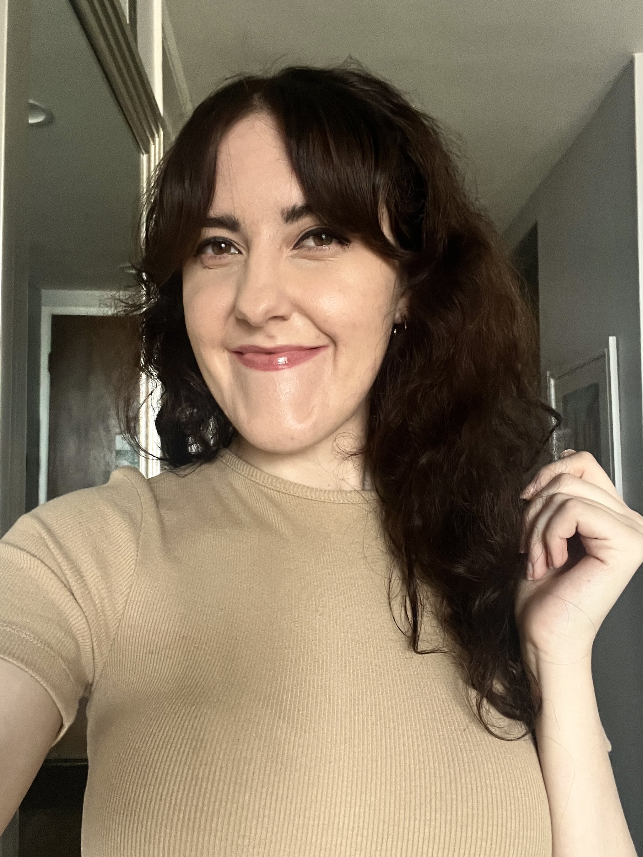 woman smiling after applying BCoBeauty bronzing drops onto face