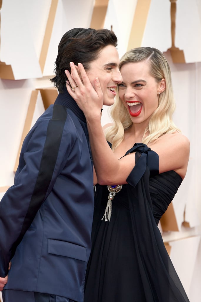 Being hollered at by photographers to smile and face in certain directions on the red carpet can only be alleviated by one thing, and that's Timothée Chalamet's charm. During Sunday night's Oscars, Margot Robbie gave the cameras her most striking poses when she was suddenly surprised by Timothée himself. That's right, the Little Women actor popped up from behind and photobombed Margot and it's the one of the greatest red carpet interactions we've seen yet. Check out their adorable exchange in front of the cameras ahead, and see photos of Margot and Timothée at the Oscars.