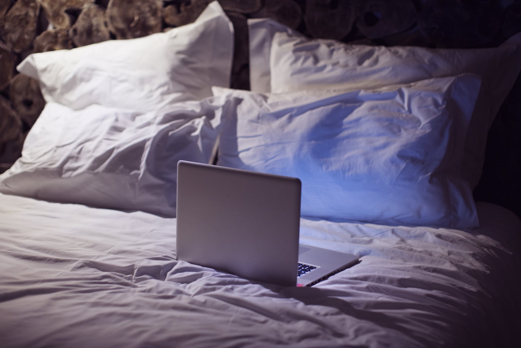 an open laptop on a bed