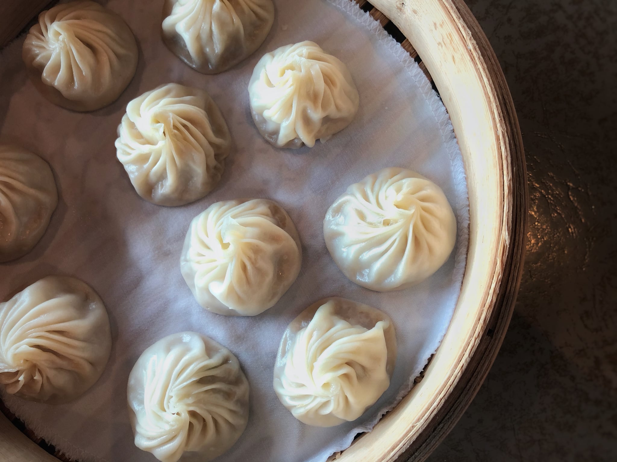 An overhead view of a basket of Chinese steam soup dumpling also known as Xiao Long Bao - 小笼包