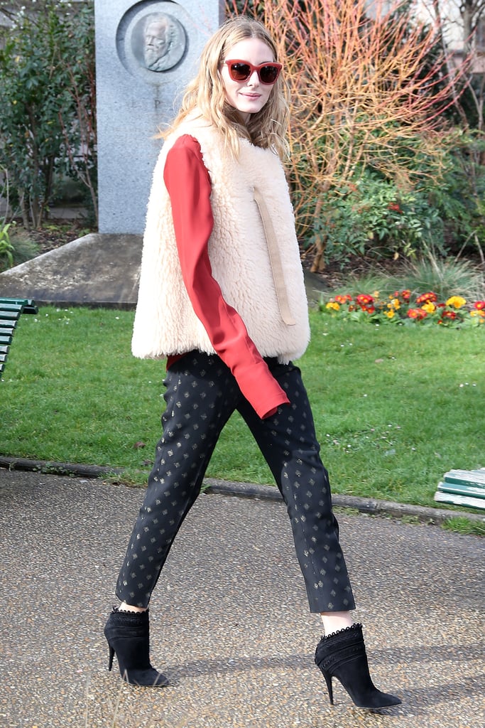 With a shearling vest, Olivia transformed printed pants, a blouse, and heels into a cozier transitional look for the shows in Paris — she even color-coordinated her sunglasses and her blouse.