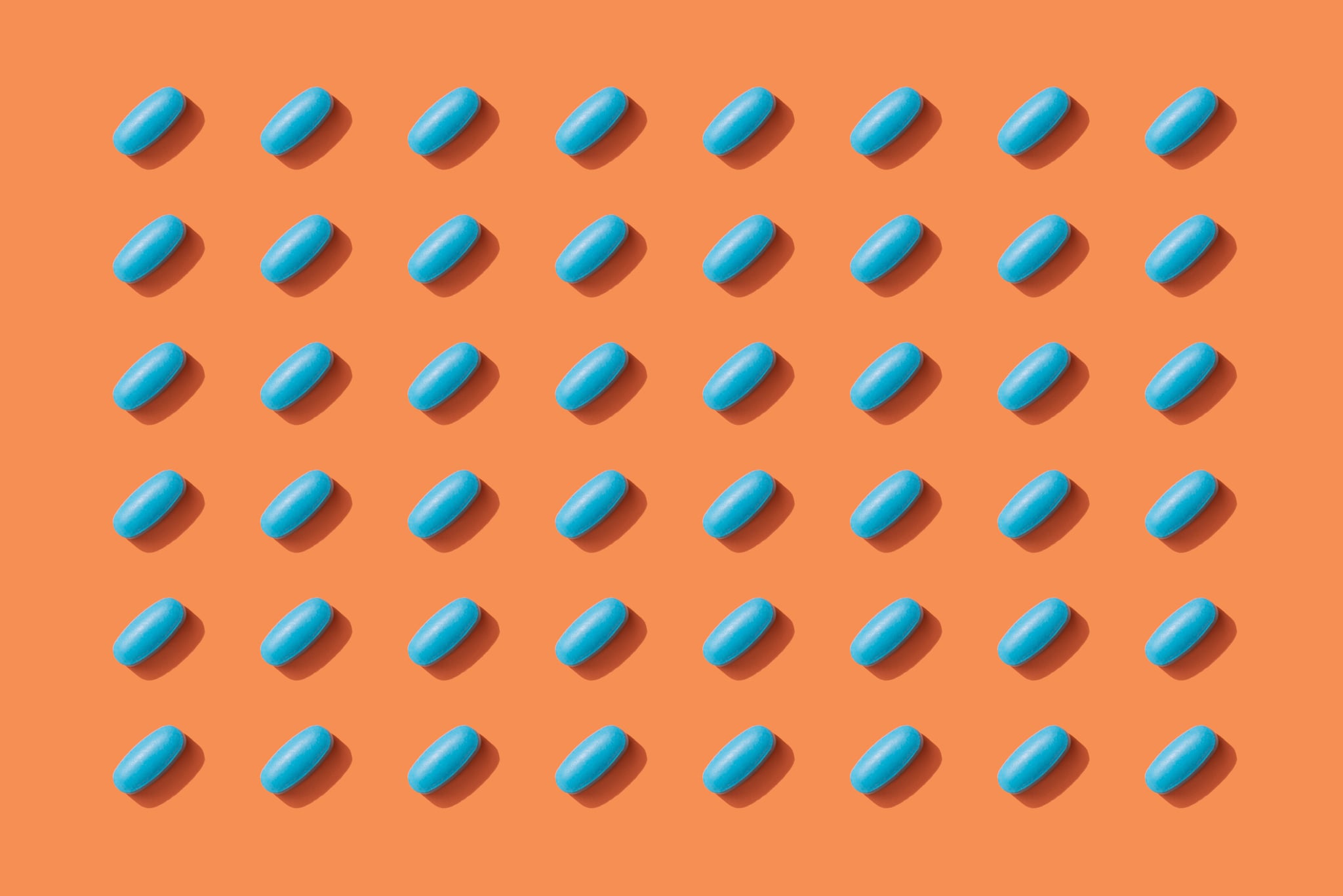 Repeated Pills on Orange Color Background