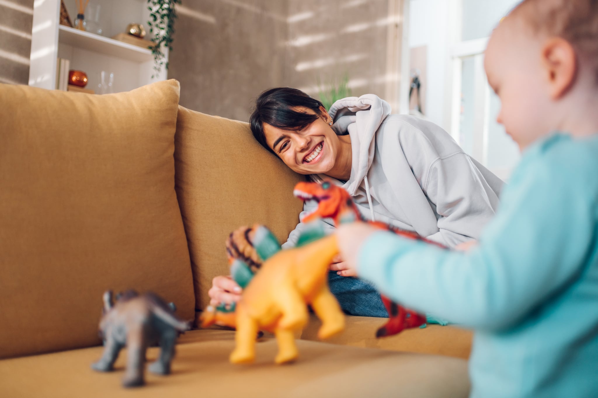 babysitter and toddler playing with dinosaurs