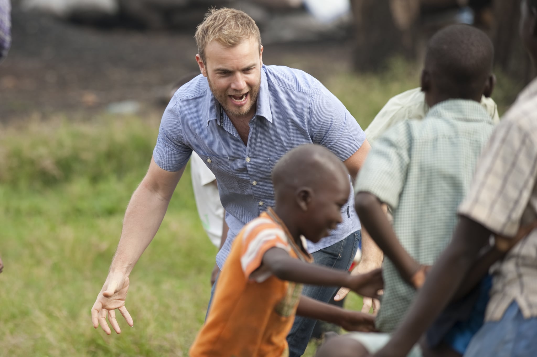 HOIMA, UGANDA - NOVEMBER 29: Gary Barlow plays with the local children before heading to the Bulimya net distribution area on November 29, 2009 in Hoima, Uganda. Five of the nine celebrity Kilimanjaro climbers, Gary Barlow, Fearne Cotton, Ben Shepherd, Chris Moyles and Kimberley Walsh, saw all their hard work climbing the mighty Mount Kilimanjaro pay off as they witnessed for themselves how some of the money raised is being spent to help to fight malaria, Africa's biggest killer. The team are revisiting Africa to see how the money raised over Red Nose Day is being spent, as well as helping to hand out malaria nets. You can see how the team got on by watching BBC One 6.30pm Sunday 27th December.  (Photo by Des Willie/Comic Relief via Getty Images)