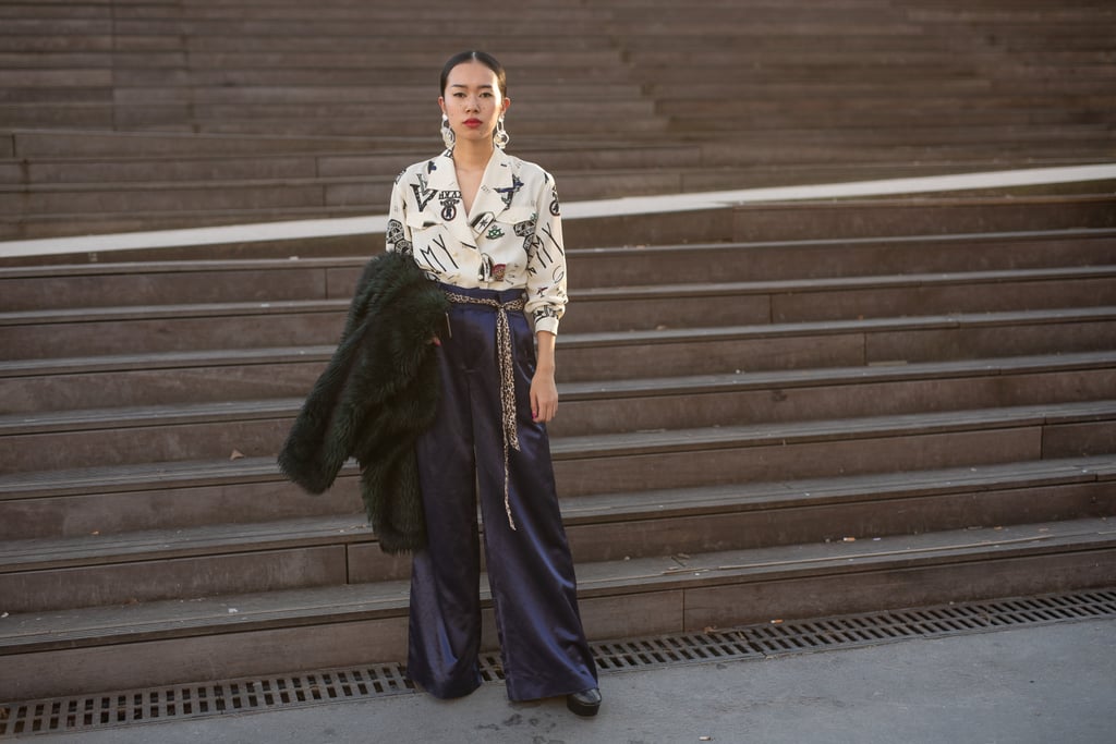 Navy trousers feel exciting with a printed blouse and statement earrings.