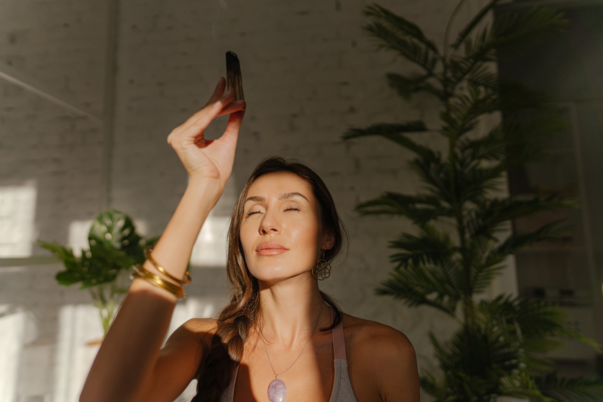 Photo of a young woman, practicing yoga and meditation, to stay healthy and calm. She is performing the exercise in her home.