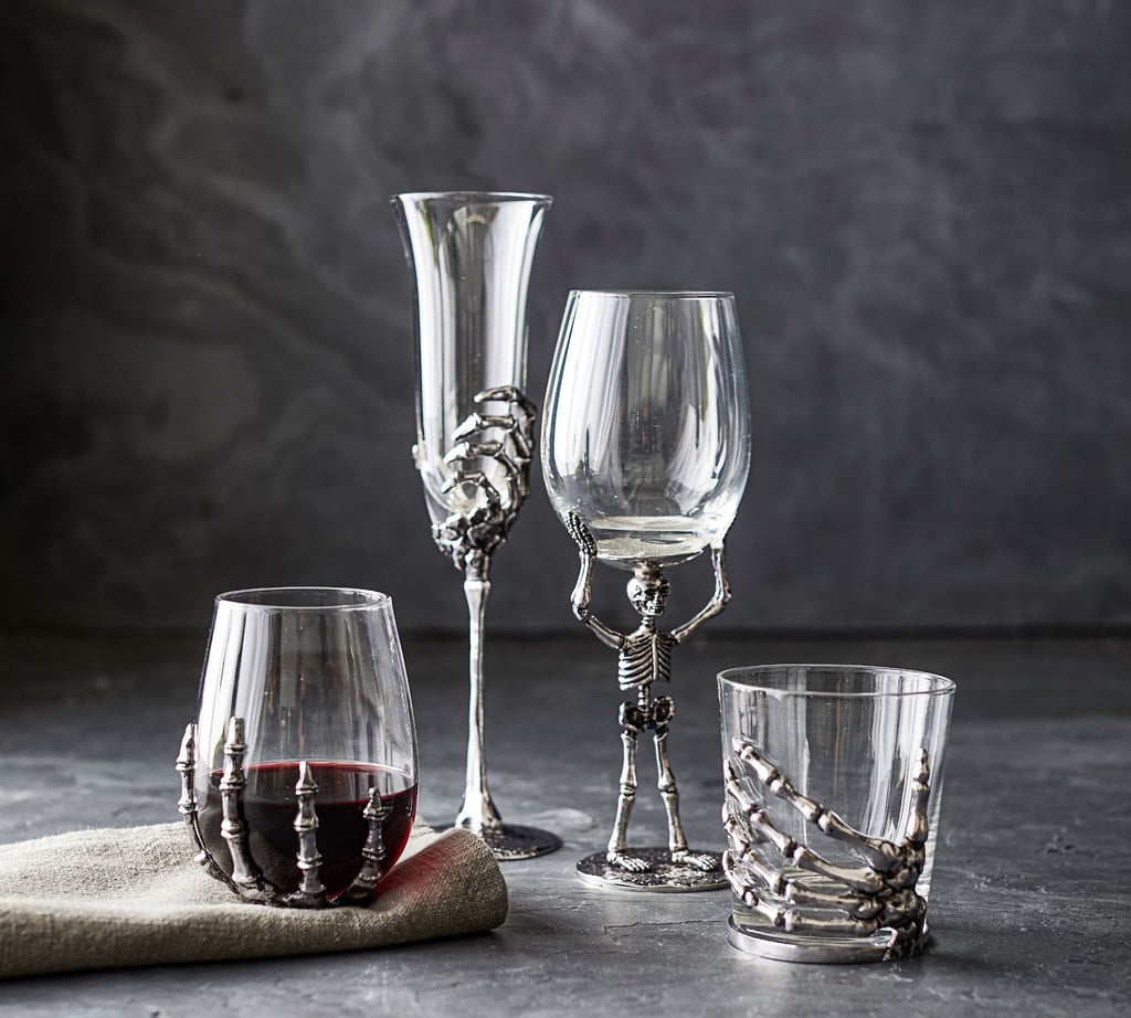 Pottery Barn Skeleton Drinkware Collection ($30-$33)
Skeleton-themed drinkware is all you need to serve up fun cocktails and drinks at your haunted home. This collection includes a full-body skeleton wine glass, a skeleton-hand stemless double old-fashioned glass, a skeleton-hand champagne flute, and a skeleton martini glass to accommodate a full spectrum of beverages. Serve up potions and punch with this stunningly haunting collection.