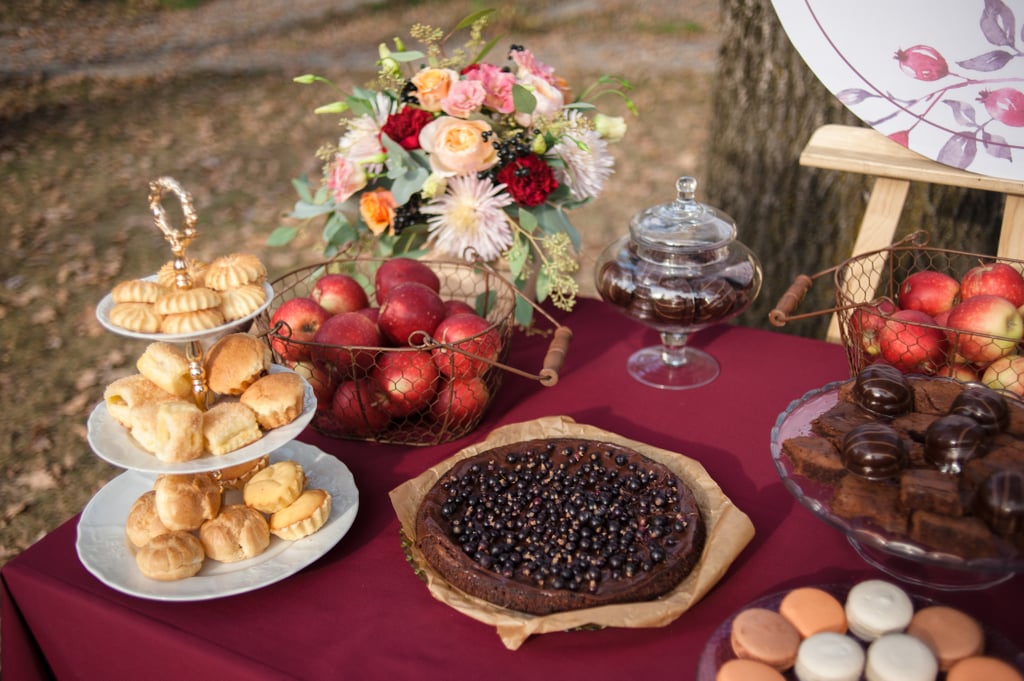 Fall Wedding Color Palettes
Classic Fall Colors
A traditional fall wedding means having a classic fall color palette, and as Fay says, you only have to look to nature to think up some ideas. "Greens, burnt oranges, browns, yellow, and red are all wonderful choices to evoke that cozy fall feeling at a wedding," she says.
For one wedding she planned, Lafferty's approach was to make the couple and guests feel as if they were strolling along a wooden walkway during the autumn season, creating the illusion of entering a fall forest or garden. "The hue of the wooden plank aisle and natural woven chairs gives it a rustic yet elegant feel. The florals, plants, and foliage nod to the season and also contribute to the harvest-inspired aesthetic, incorporating unique elements such as fruits and vegetables requested by the couple," she says.
Plums and Berries
A fall color palette with plum and berry tones can add a richness and moodiness to your event. "The colors complement florals so well that florists are always excited to work with this combination," says Fay. "It's romantic and ethereal, especially with candlelight, and it goes great in a more wild setting — like a rustic backdrop or field or anything natural with greens or browns all around."
Fall Wedding Food
Fall Canapés
Fall-inspired canapés are a great way to tap into your guest's taste sensory. Lafferty says to try to combine seasonal fall ingredients with familiar fall flavors, such as warm spices (like cinnamon, ginger, and cloves), butternut squash with sweet maple and brown butter, pumpkin and sage, and fresh pomegranate and figs.
Harvest Table
A crowd favorite, harvest grazing tables are delicious and attractive — especially when elements of fall are brought in. "I always use a bountiful mix of fresh seasonal fruits, including figs, pomegranates, grapes, apples, and pears, along with spiced nuts or caramelized walnuts, rustic breads and crackers, and an assortment of domestic and exotic premium cheeses," says Lafferty. "I also like to include small canapés, such as stuffed artichoke bottoms and bacon-wrapped stuffed dates, for a comforting touch that complements the fall harvest theme."

    Related:

            
            
                                    
                            

            10 Backyard Wedding Ideas for an Elevated At-Home Ceremony
        
    
Michelle Rostamian is a Los Angeles-based beauty and wellness contributor with over 10 years of experience in the industry. She began her career as a publicist, content writer, and social media manager, representing beauty brands and industry professionals. Currently, she is a writer and editor on all things makeup, beauty, skincare, and lifestyle.