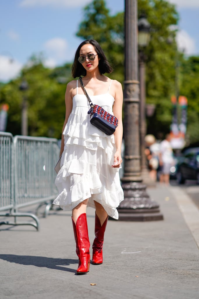 Wear a cherry red cowboy boot with a romantic, tiered knee-length dress.