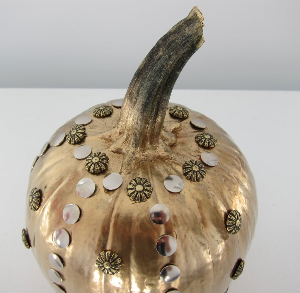 Continue adding studs along the sides and top of the pumpkin, making sure the spaces between each stud/embellishment are equidistant to one another.