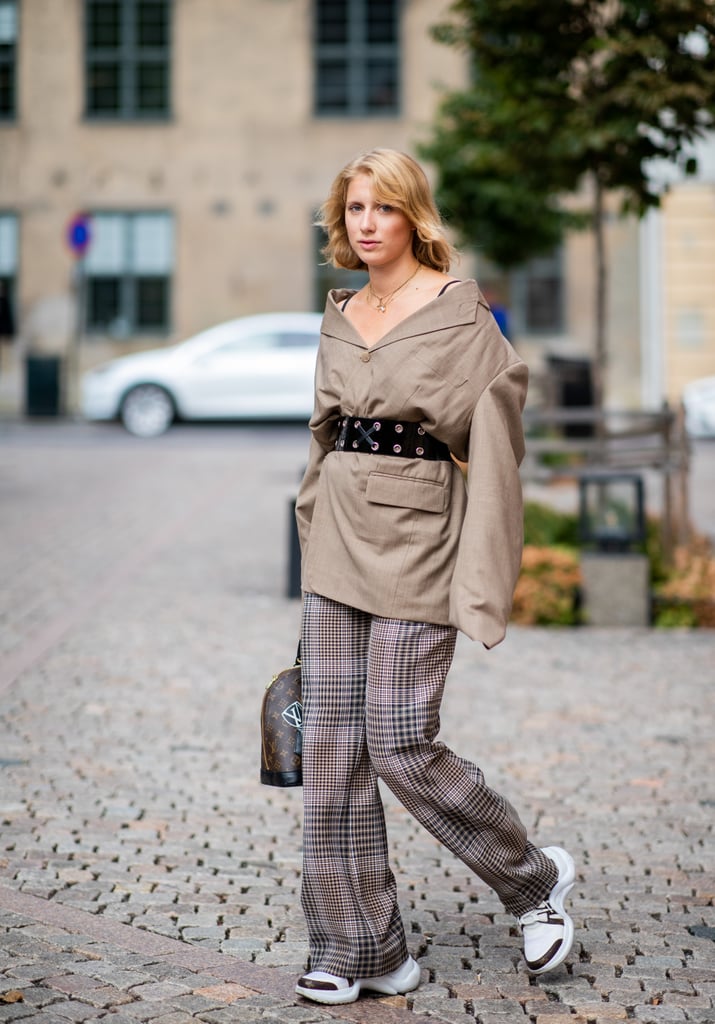 Give plaid pants a cool upgrade with an off-the-shoulder top and stylish trainers.