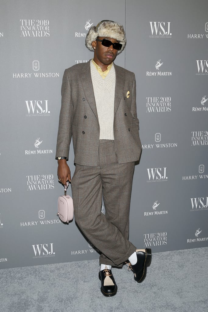 At the 2019 WSJ. Magazine Innovator Awards, Tyler styled his suit with a fuzzy hat and a light pink bag.