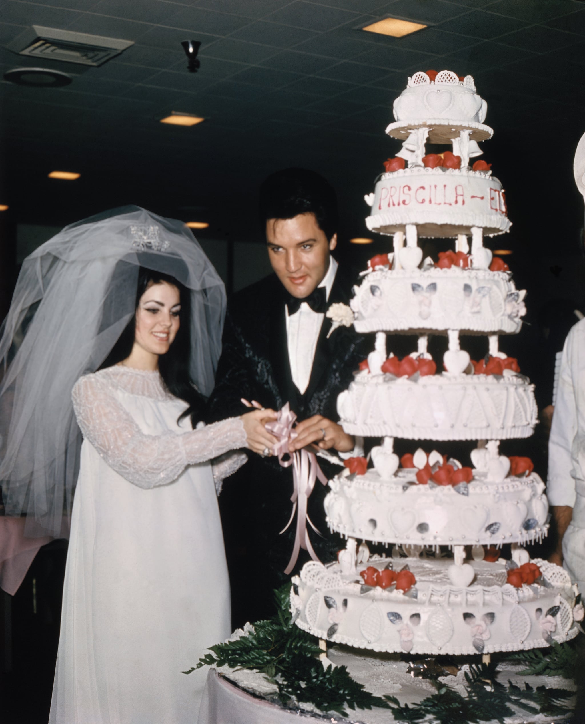 (Original Caption) Las Vegas, Nevada, Entertainer, Elvis Presley cuts wedding cake with his bride, the former Priscilla Ann Beaulieu, May 1, 1967.