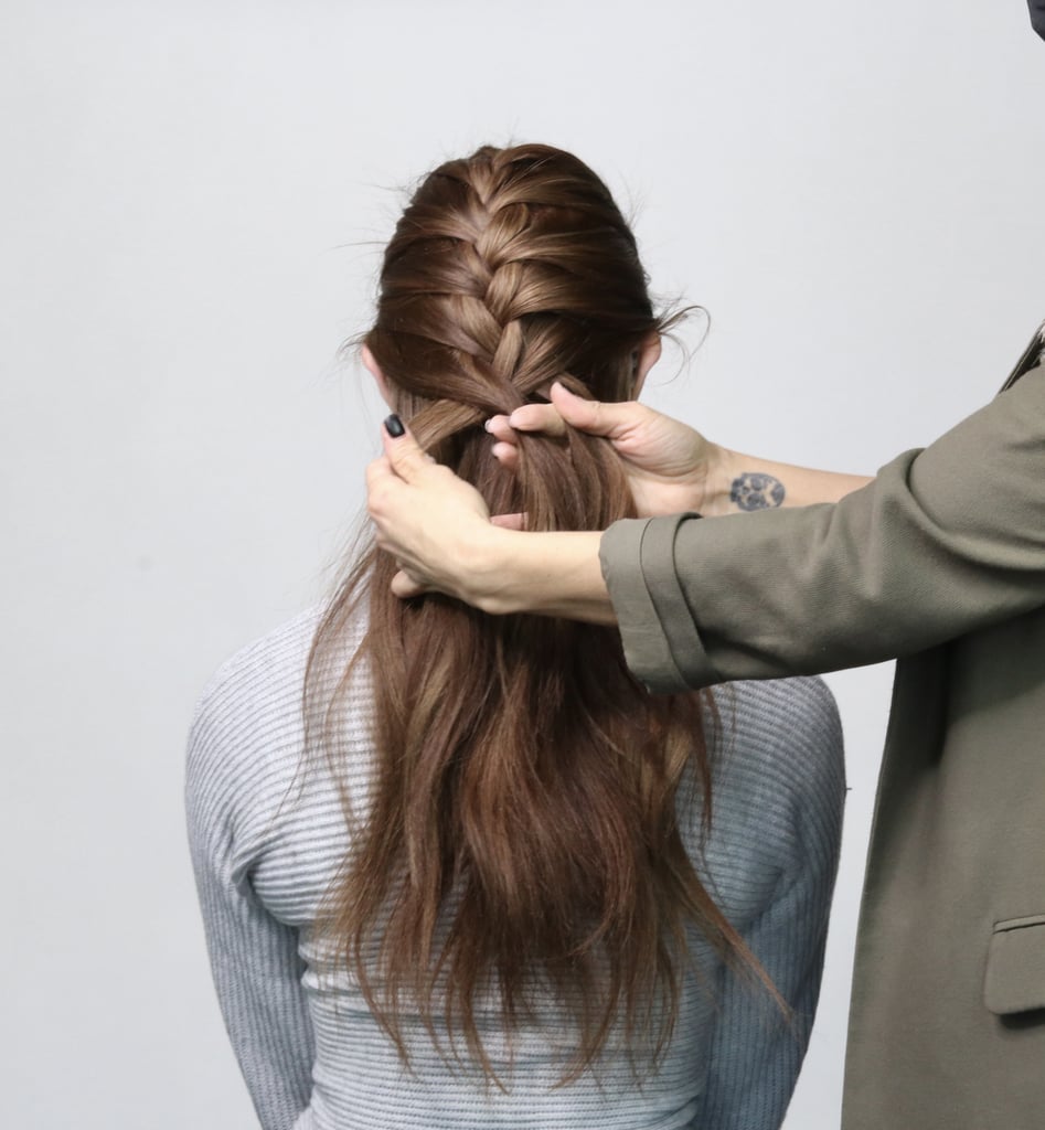 Every time you cross over, grab a one-inch section of hair behind your ear and near the hairline on your neck, and work it into the weaved section. Continue to cross the larger piece of hair on either side over the middle section of the braid.