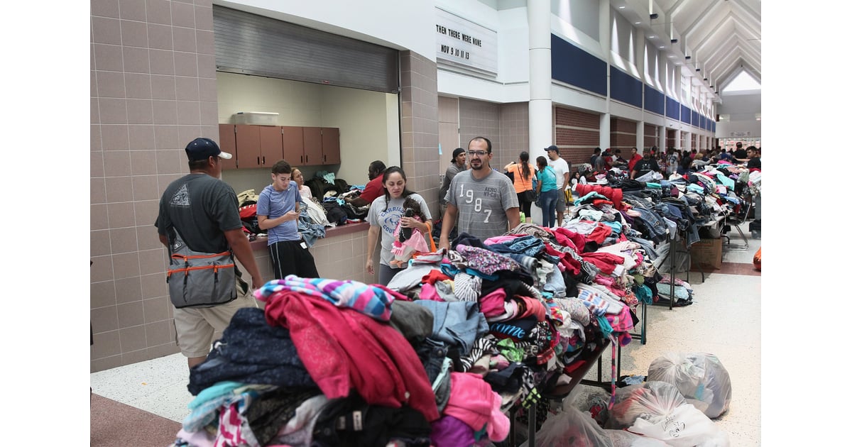 People gather by donated clothes at a shelter. Hurricane Harvey