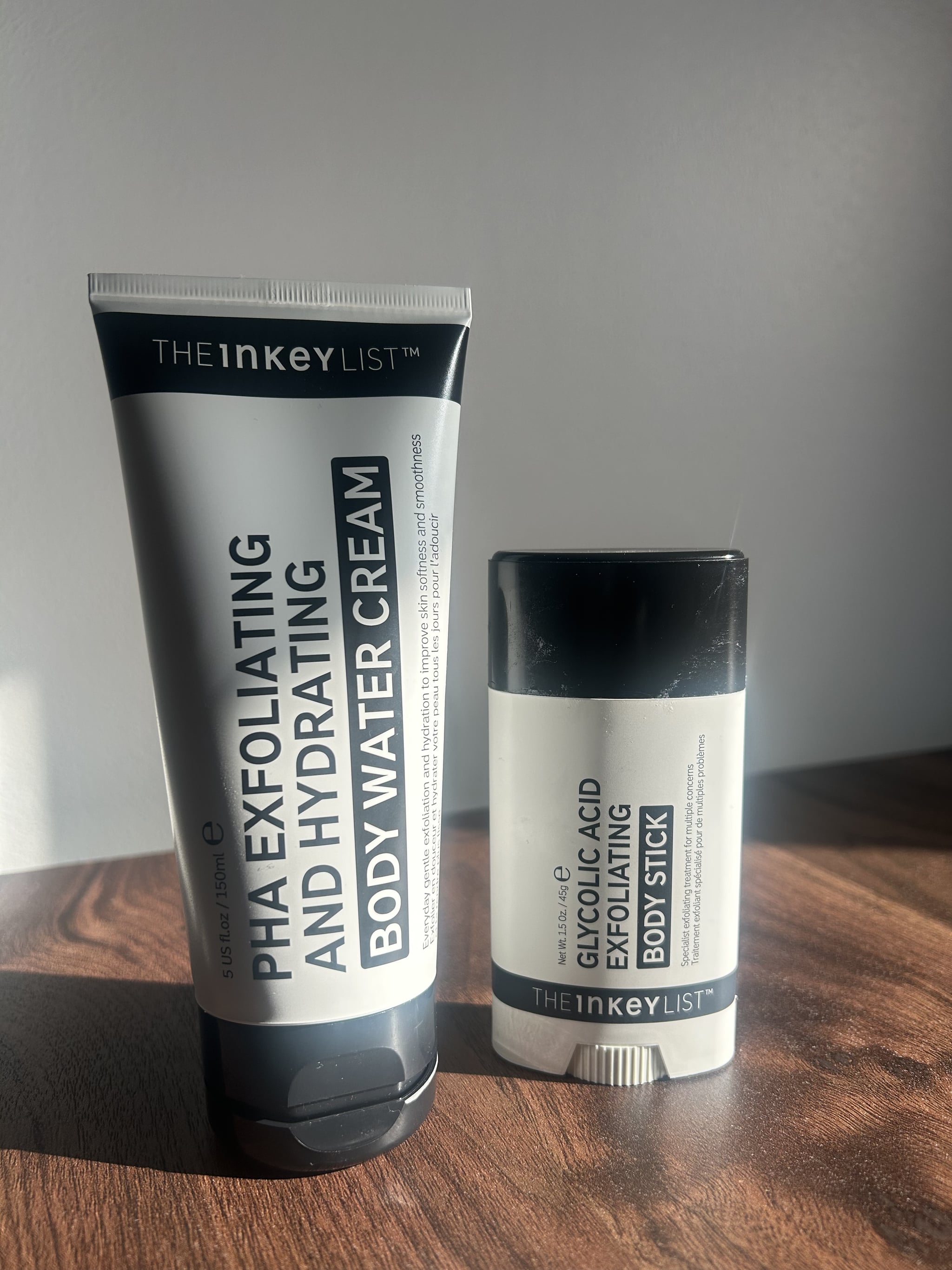 The Inkey List Exfoliating Body Water Cream and Body Stick on a wooden table