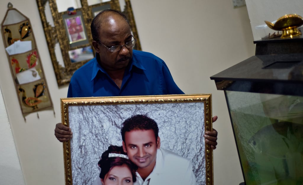 Subramaniam Gurusamy held a portrait of his son Puspanathan, one of the passengers on MH370.