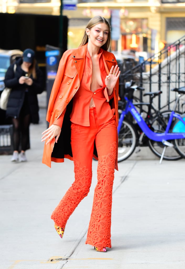 Gigi wore a head-to-toe orange look while walking around NYC in December, pairing a blazer and matching trousers by Ronald van der Kamp. She paired the look with a leather Moschino trench coat and Christian Louboutin ankle boots.