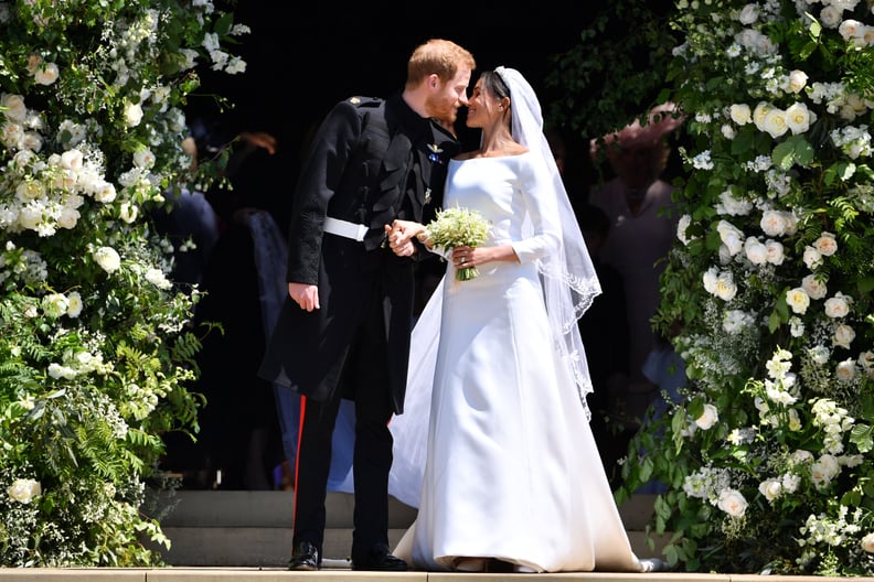 Britain's Prince Harry, Duke of Sussex kisses his wife Meghan, Duchess of Sussex as they leave from the West Door of St George's Chapel, Windsor Castle, in Windsor, on May 19, 2018 after their wedding ceremony. (Photo by Ben STANSALL / POOL / AFP)        