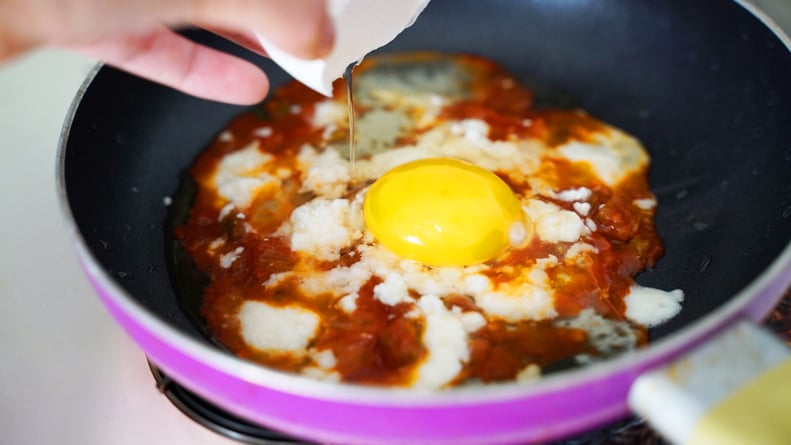 how to make feta fried eggs: crack egg into pan