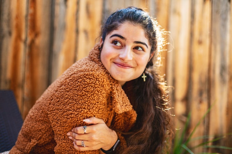 Woman Outside Holding Her Hands Around Her Body and Looking to the Side