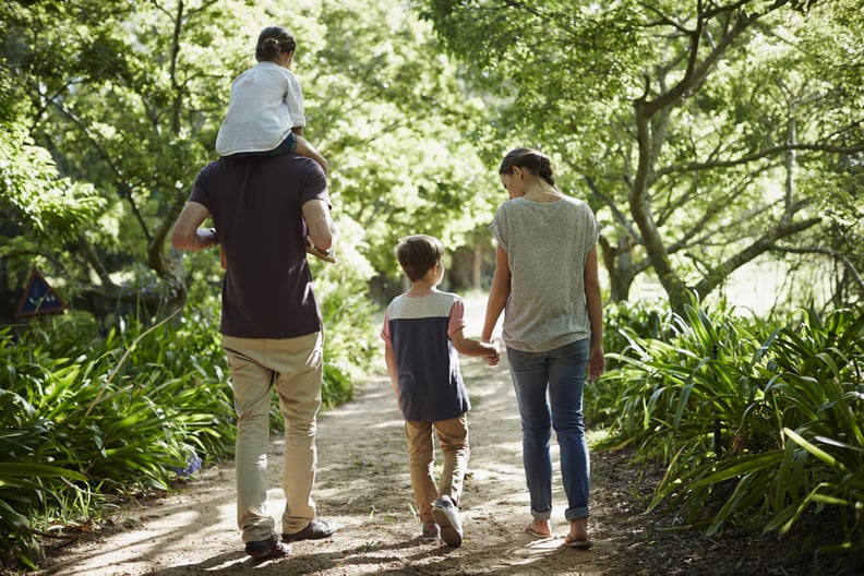 Full length rear view of two generation family walking on path in park