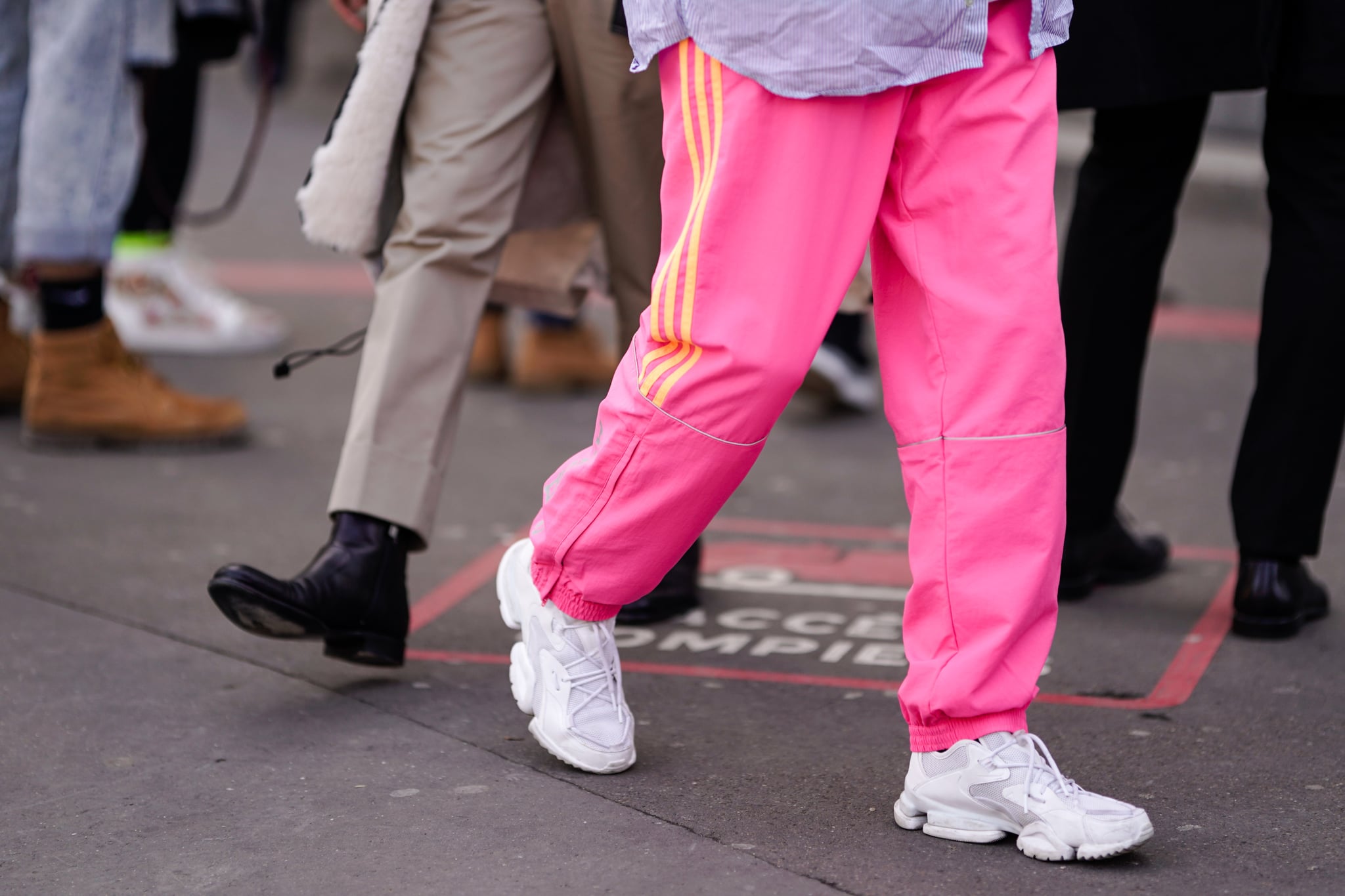 PARIS, FRANCE - JANUARY 18: A guest wears pink sports pants with yellow stripes, white sneakers, during Paris Fashion Week - Menswear F/W 2019-2020, on January 18, 2019 in Paris, France. (Photo by Edward Berthelot/Getty Images)